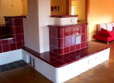 Vínově červená kachlová kamna s bílým soklem v obývacím pokoji